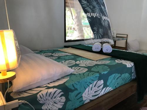 a bed with two pillows and a window at Phangan Villa Bungalows in Thongsala