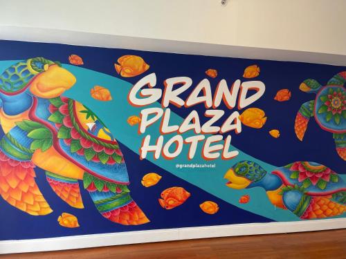 a sign for a grand plaza hotel with two parrots at Grand Plaza Hotel in Tumon