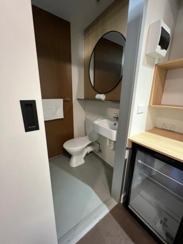ein Badezimmer mit einem WC, einem Waschbecken und einem Spiegel in der Unterkunft The Sea Pavilions in Cowes