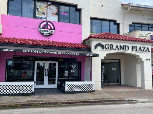 a pink and white building with a grand pizzeria at Grand Plaza Hotel in Tumon