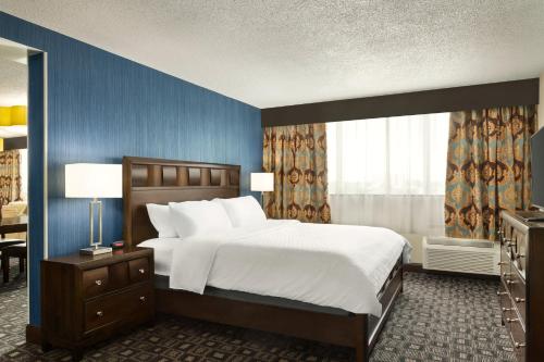 a bedroom with a large bed and a blue wall at Holiday Inn Louisville East - Hurstbourne by IHG in Louisville