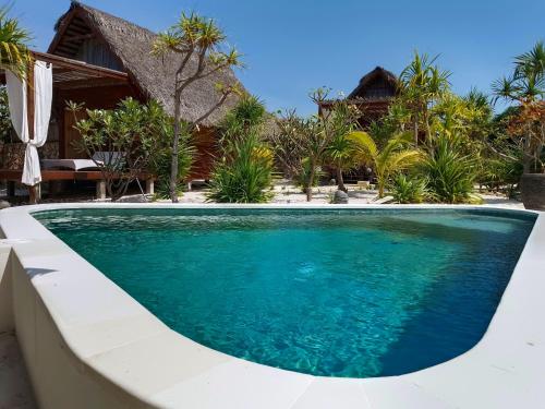 a swimming pool in front of a resort at Loedi Bungalows Rote in Nembrala