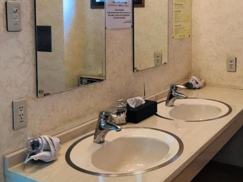 a bathroom with two sinks and two mirrors at Lake Side Nikko Hotel in Nikko