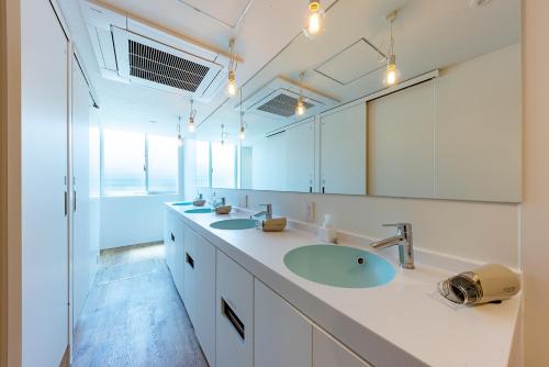 a bathroom with two sinks and a large mirror at plat hostel keikyu kamakura wave in Kamakura