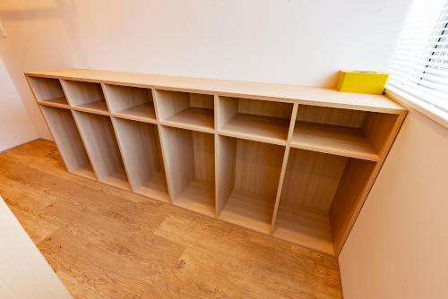 a book shelf in a room with a window at plat hostel keikyu kamakura wave in Kamakura