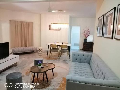 uma sala de estar com um sofá azul e uma mesa em PD Lagoon Resort em Porto Dickson