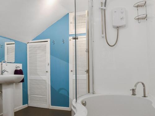 a bathroom with a shower and a tub and a sink at Ashgrove Cottage in Dudbridge