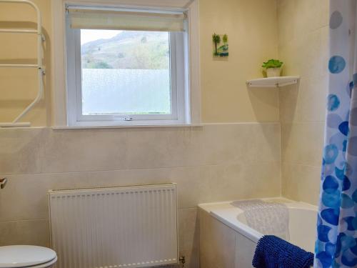 a bathroom with a bath tub and a window at Westholme in Saint Fillans