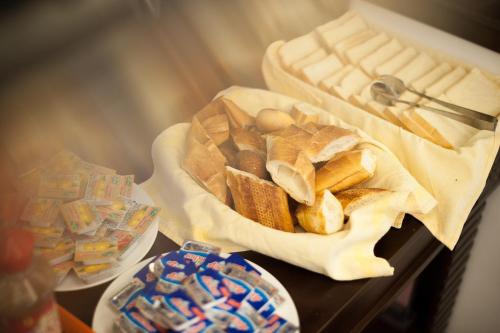 un tavolo con un cestino di pane e altri snack di Lefoyer Hotel a Hanoi