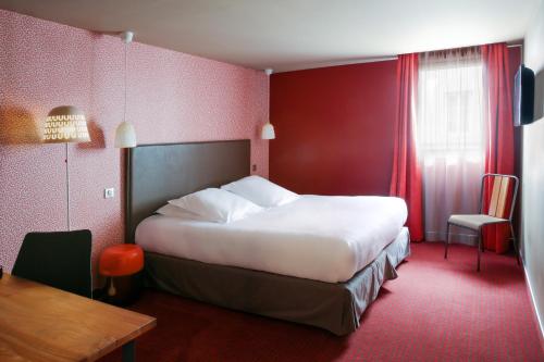 a hotel room with a large bed and a table at Best Western Citadelle in Besançon