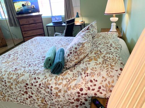 Una cama con dos almohadas azules encima. en Countryside comfort Suite with private bathroom, en Hemet