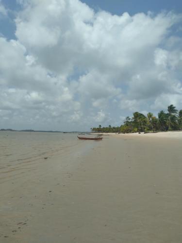 un bateau sur une plage avec des arbres en arrière-plan dans l'établissement Pousada Sol da Ilha, à Igrapiúna