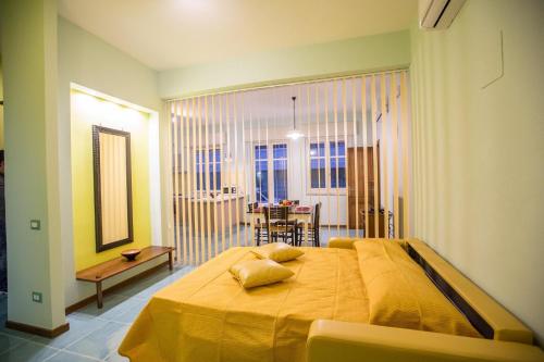 a bedroom with a large yellow bed and a dining room at Il Nido del sole in Cefalù