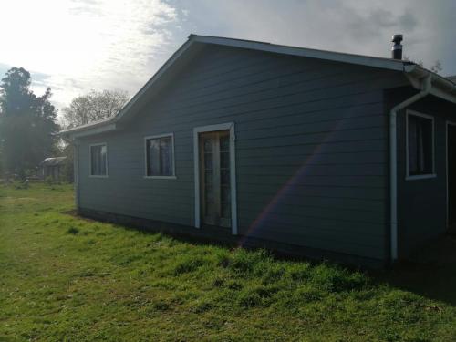 a small house with a green at Alojamiento Freire - Caviahue in Freire