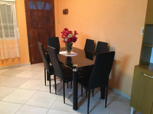 a table with black chairs and a vase of flowers on it at Cami III in Piriápolis
