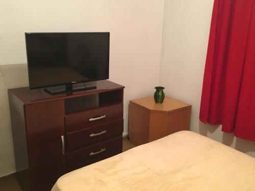 a bedroom with a television on a dresser with a bed at Cami III in Piriápolis