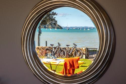 a mirror reflecting a table with bikes parked around it at Seaside on Waiheke - Stay Waiheke in Blackpool
