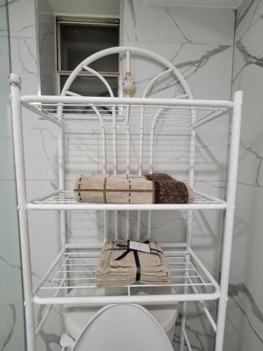 a white shelf in a bathroom with towels on it at Falstaff Home in Toronto