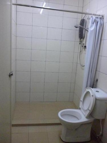 a bathroom with a white toilet and a shower at Abby by the river in Ipoh