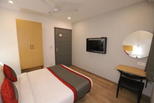 a bedroom with a bed and a desk and a mirror at Hotel IP Residency Anand Vihar in New Delhi