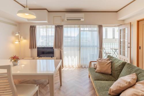 sala de estar con sofá y mesa en Universal Bay Condominium en Osaka