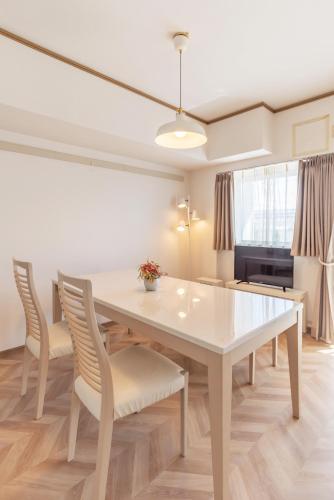a dining room with a white table and chairs at Universal Bay Condominium in Osaka