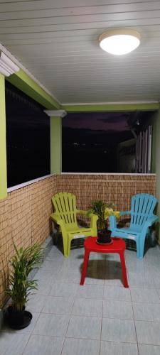 2 chaises et une table rouge sur une terrasse dans l'établissement Le petit cactus 2, à Bras-Panon