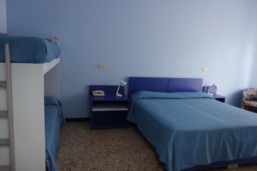 um quarto azul com uma cama e uma mesa de cabeceira em Hotel Corallo em Pietra Ligure
