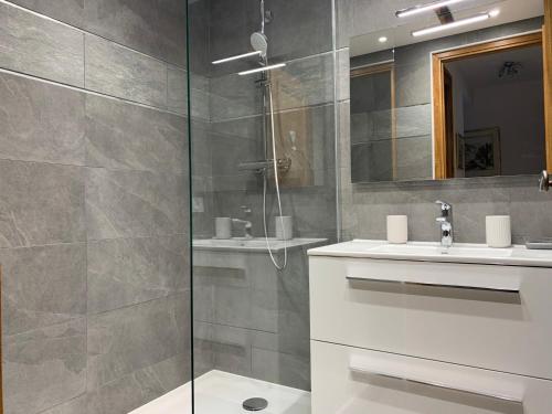 une salle de bain avec une douche, un lavabo et un miroir dans l'établissement Appartement à Chamonix avec terrasse, parking, local à skis - FR-1-343-172, à Chamonix-Mont-Blanc