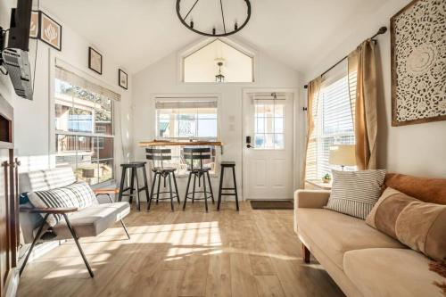 a living room with a couch and a clock on the wall at NEW! Boutique TinyHome w/Direct View of PikesPeak! in Woodland Park