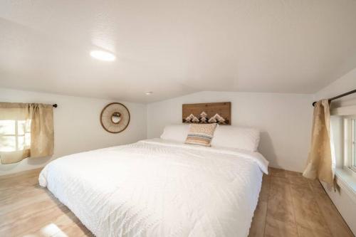 a white bedroom with a large white bed in it at NEW! Boutique TinyHome w/Direct View of PikesPeak! in Woodland Park
