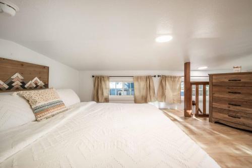 a bedroom with a large white bed and a window at NEW! Boutique TinyHome w/Direct View of PikesPeak! in Woodland Park