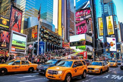 a busy city street filled with taxis and people at LGA airport 3 mins, 3 BR Duplex House, Parking and private backyard, 9mins subway! in East Elmhurst