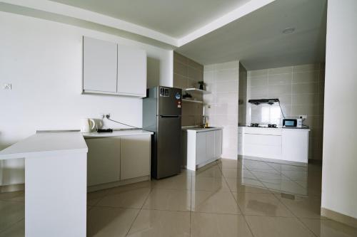 a kitchen with white cabinets and a black refrigerator at Sky Bungalow NIlai by James NEARBY KLIA, KLIA 2, CYBERJAYA, PUTRAJAYA in Nilai