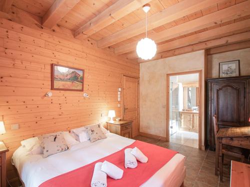 Cette chambre en bois comprend un grand lit. dans l'établissement Chalet de charme à Chamonix, 6 chambres, jardin, parking, wifi - FR-1-343-226, à Chamonix-Mont-Blanc