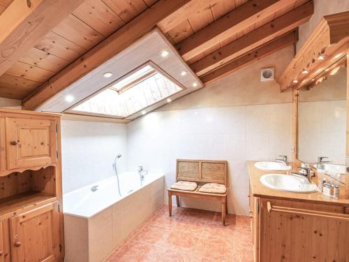 La salle de bains est pourvue de 2 lavabos, d'une baignoire et d'une fenêtre. dans l'établissement Chalet de charme à Chamonix, 6 chambres, jardin, parking, wifi - FR-1-343-226, à Chamonix-Mont-Blanc