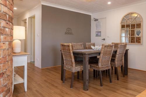 a dining room with a table and chairs at Coastal Retreat 10 Champagne Court in Tuncurry