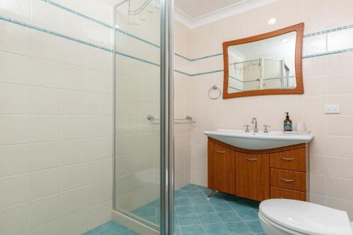 bagno con doccia, lavandino e servizi igienici di Coastal Retreat 10 Champagne Court a Tuncurry