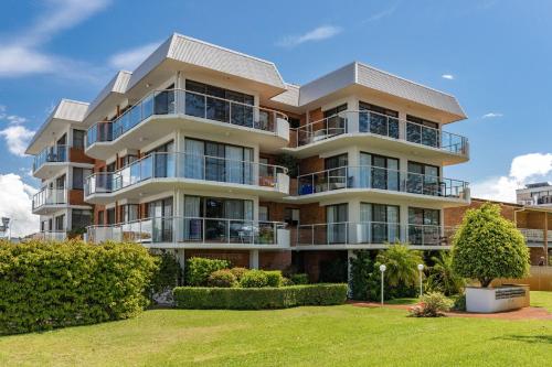 an apartment building with balconies and bushes at Coastal Retreat 10 Champagne Court in Tuncurry
