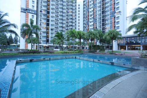 a large swimming pool with palm trees and buildings at SarangSinggah@Timurbay Seafront in Kuantan