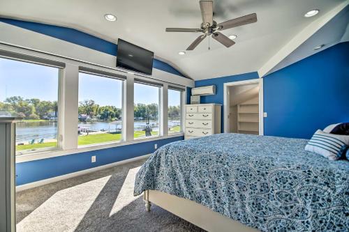 1 dormitorio con paredes azules y 1 cama con ventilador de techo. en Modern and Chic Waterfront Getaway in McHenry!, en McHenry