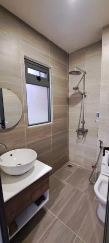 een badkamer met een wastafel en een toilet en een raam bij Ánh Dương House in Da Lat