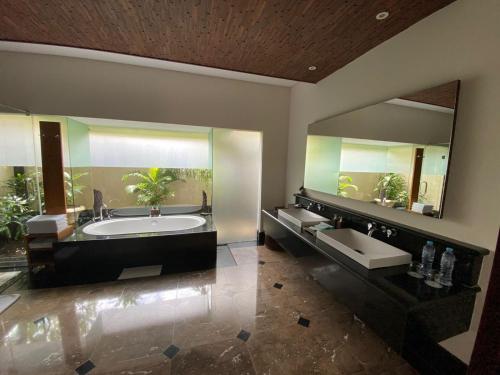a bathroom with two sinks and a large mirror at Bintang Bali Villa in Kuta