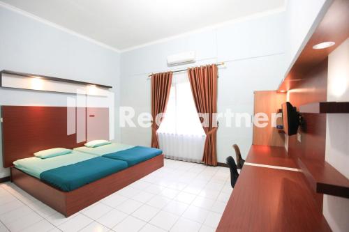 En eller flere senge i et værelse på Hotel Mexicanna Syariah Mitra RedDoorz