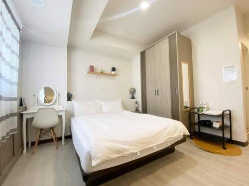 um quarto com uma cama, uma secretária e um espelho em Tainan Homestay em Tainan