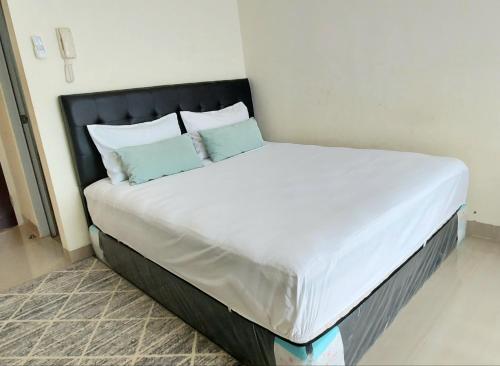 - un grand lit blanc avec 2 oreillers dans l'établissement Tmn Melati Margonda-Relaxed and Friendly, à Pondokcina