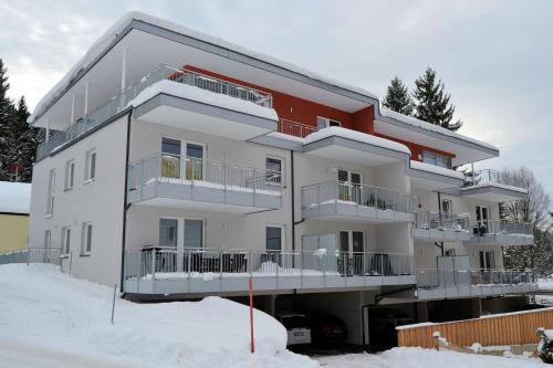 a white apartment building in the snow at Panoramaresidenz Scheffau am Wilden Kaiser in Scheffau am Wilden Kaiser