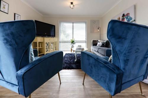 デイルスフォードにあるHidden Gem ~ Luxury Cottage near Lake Daylesfordのリビングルーム(青い椅子2脚、ソファ付)