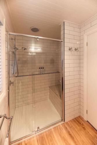 a shower with a glass door in a bathroom at Hidden Gem ~ Luxury Cottage near Lake Daylesford in Daylesford