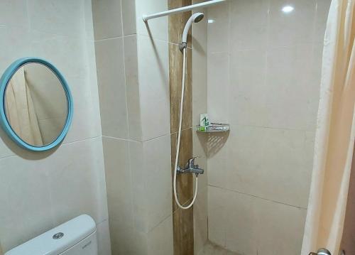 La salle de bains est pourvue d'une douche avec miroir et de toilettes. dans l'établissement Tmn Melati Margonda-Relaxed and Friendly, à Pondokcina